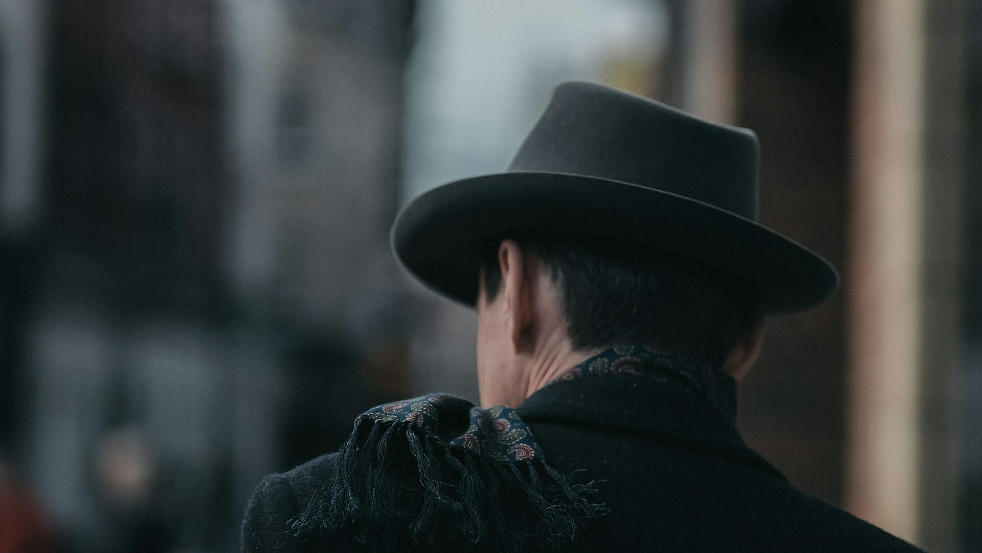 Detective walking away from frame down an empty street